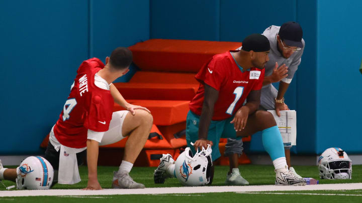 Jul 24, 2024; Miami Gardens, FL, USA; Miami Dolphins head coach Mike McDaniel talks to quarterback Tua Tagovailoa (1) during training camp at Baptist Health Training Complex.