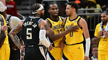 Indiana Pacers guard Tyrese Haliburton is restrained by forward Aaron Nesmith as Milwaukee Bucks guard Gary Trent Jr.