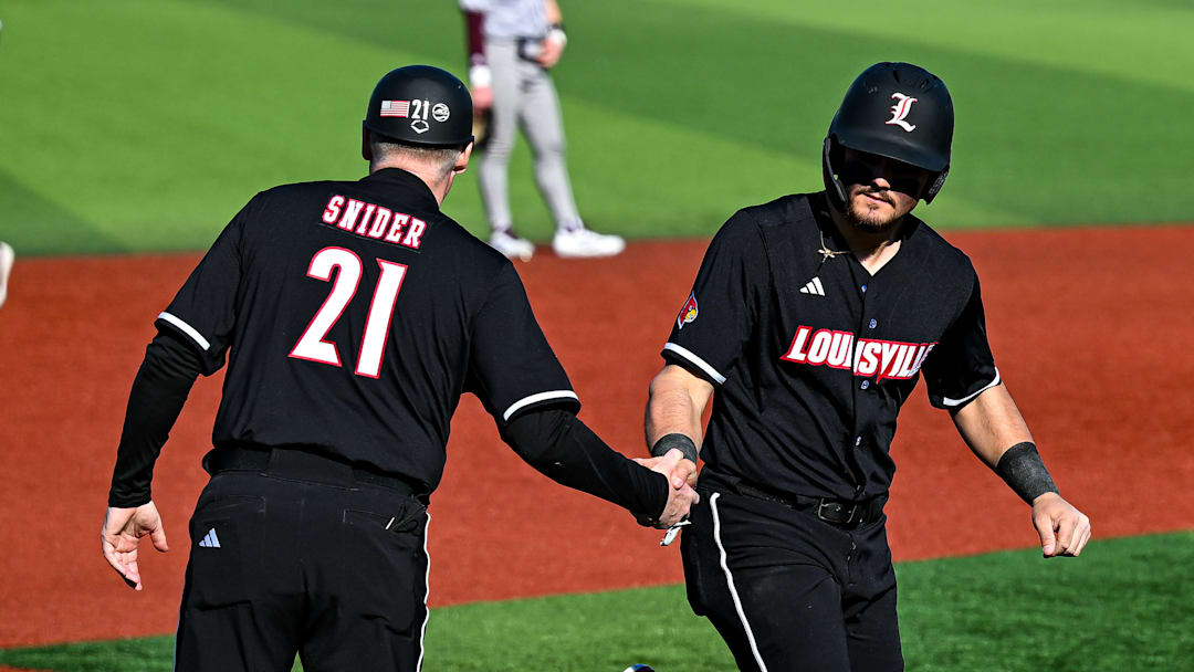 Louisville third base coach Eric Snider congratulates first baseman Tague Davis as he rounds the bases after hitting a home run. Louisville third base coach Eric Snider congratulates first baseman Tague Davis as he rounds the bases after hitting a home run.