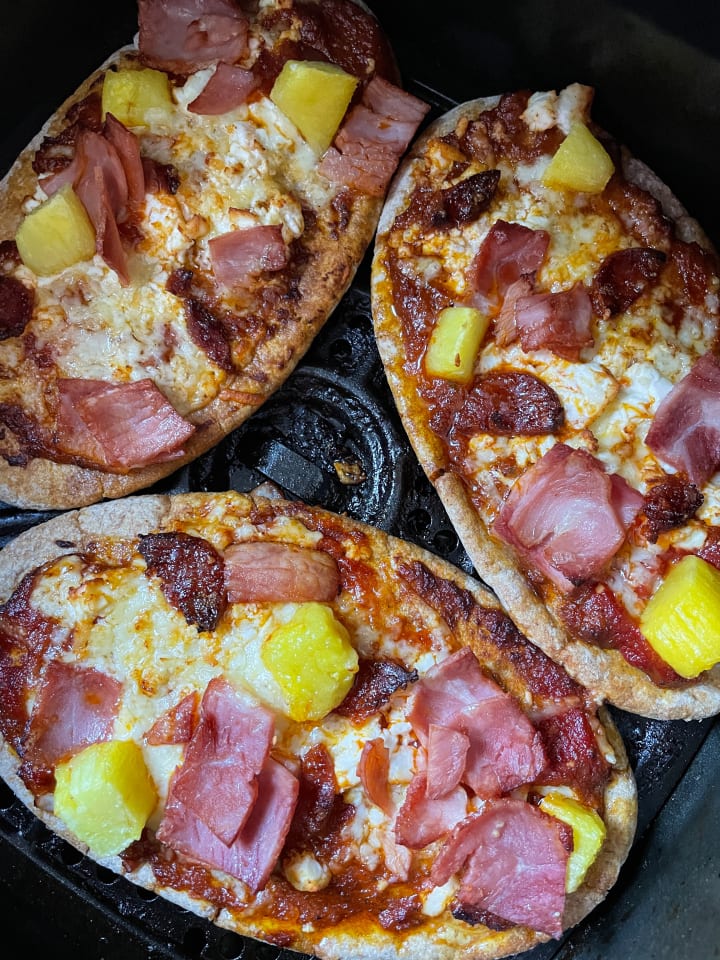 three pieces of Hawaiian pizza in an air fryer