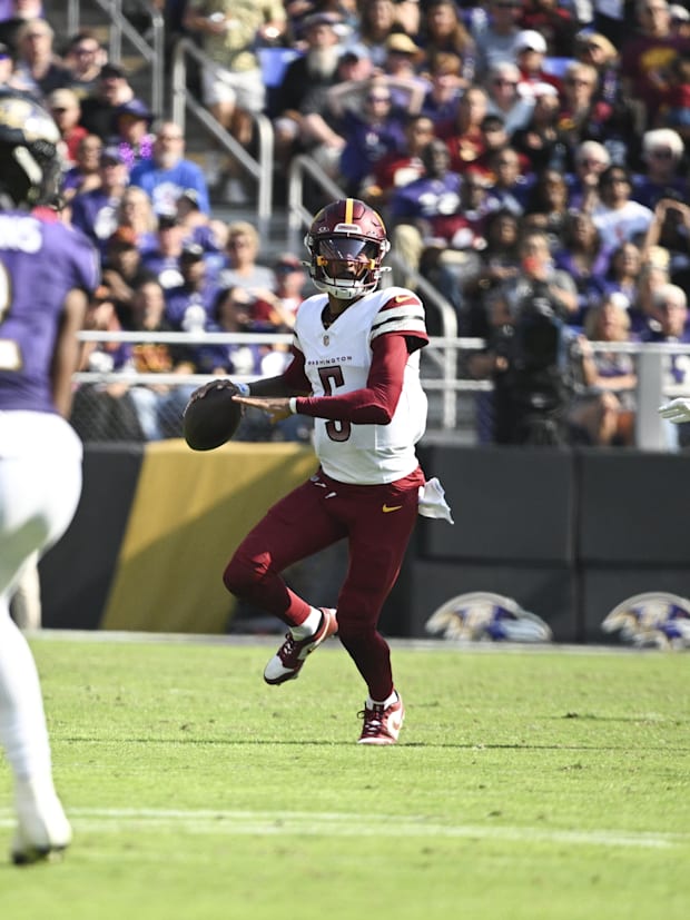 Washington Commanders quarterback Jayden Daniels (5) looks to throw on the run.