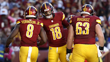 Oct 20, 2024; Landover, Maryland, USA; Washington Commanders running back Brian Robinson Jr. (8) celebrates with Commanders quarterback Marcus Mariota (18) after scoring a touchdown against the Carolina Panthers during the second quarter at Northwest Stadium. Mandatory Credit: Geoff Burke-Imagn Images