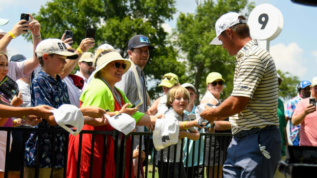 Bryson DeChambeau of Crushers GC signs a hat for a fan at Geodis Park in Nashville, Tenn.