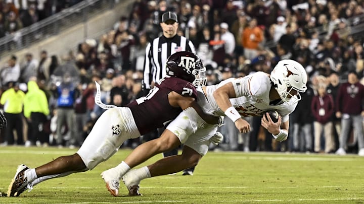 Nov 30, 2024; College Station, Texas, USA; Texas A&M Aggies linebacker Taurean York (21) tackles Texas Longhorns quarterback Arch Manning (16) during the second half. The Longhorns defeated the Aggies 17-7 at Kyle Field. Mandatory Credit: Maria Lysaker-Imagn Images  