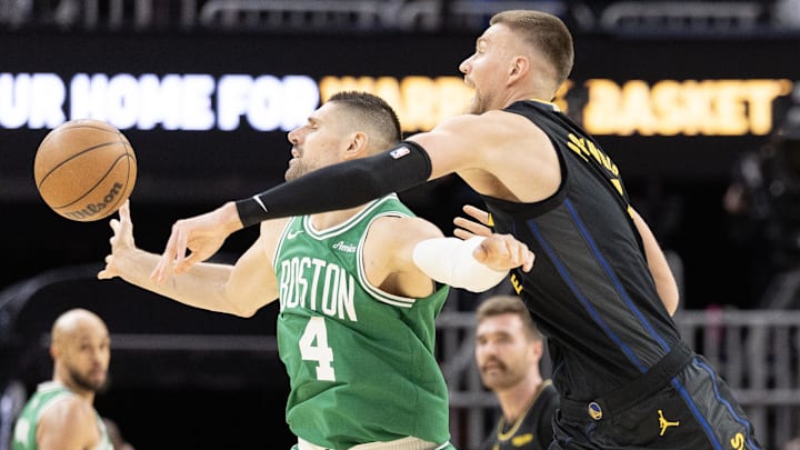 Feb 19, 2026; San Francisco, California, USA; Golden State Warriors center Kristaps Porziņgis (7) swats the ball away from Boston Celtics center Nikola Vucevic (4) during the fourth quarter at Chase Center. Mandatory Credit: D. Ross Cameron-Imagn Images