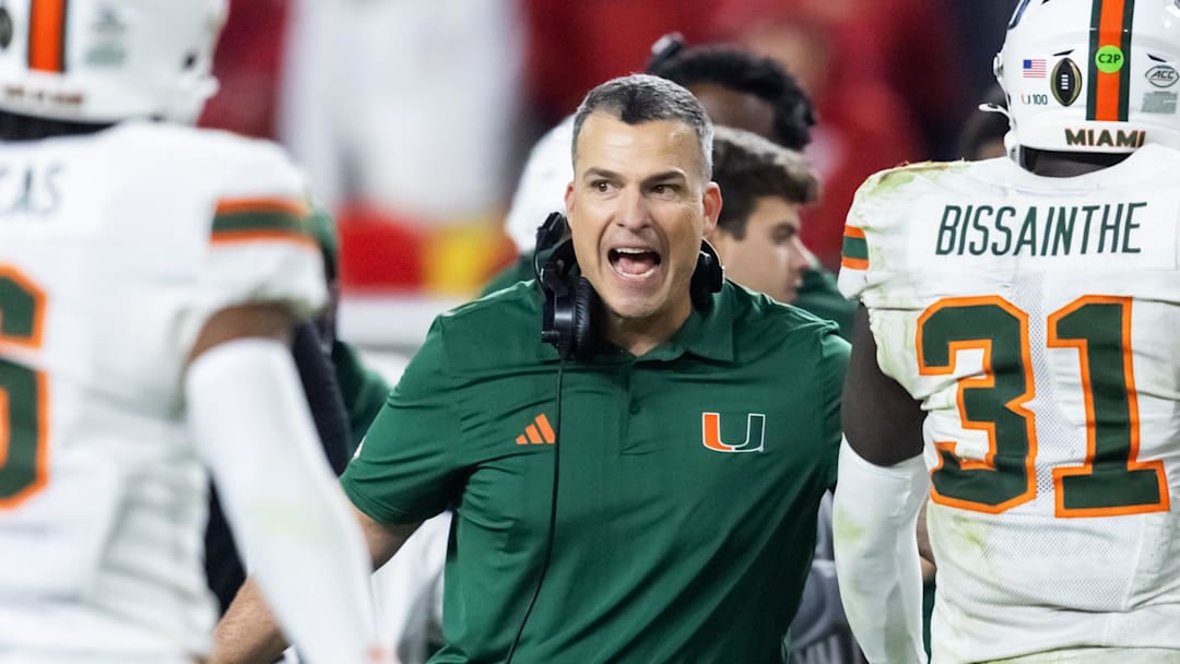 Jan 19, 2026; Miami Gardens, FL, USA; Miami Hurricanes head coach Mario Cristobal with linebacker Wesley Bissainthe (31) against the Indiana Hoosiers during the College Football Playoff National Championship game at Hard Rock Stadium. Mandatory Credit: Mark J. Rebilas-Imagn Images