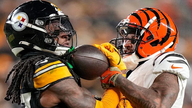 Pittsburgh Steelers cornerback Cory Trice Jr. (27) and Cincinnati Bengals wide receiver Ja'Marr Chase (1) tussle over a dead
