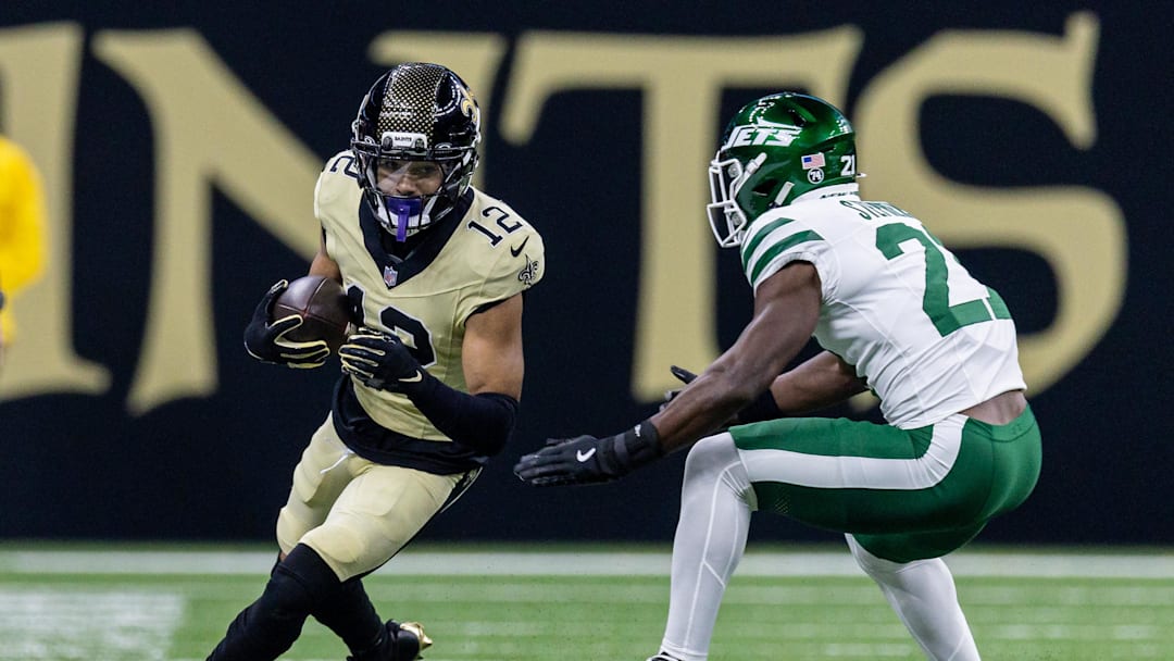 Dec 21, 2025; New Orleans, Louisiana, USA;  New Orleans Saints wide receiver Chris Olave (12) catches a pass and is chased out of bounds bye New York Jets cornerback Brandon Stephens (21) during the first half  at Caesars Superdome. Mandatory Credit: Stephen Lew-Imagn Images