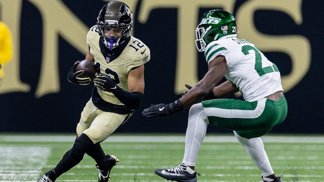 Dec 21, 2025; New Orleans, Louisiana, USA;  New Orleans Saints wide receiver Chris Olave (12) catches a pass and is chased out of bounds bye New York Jets cornerback Brandon Stephens (21) during the first half  at Caesars Superdome. Mandatory Credit: Stephen Lew-Imagn Images