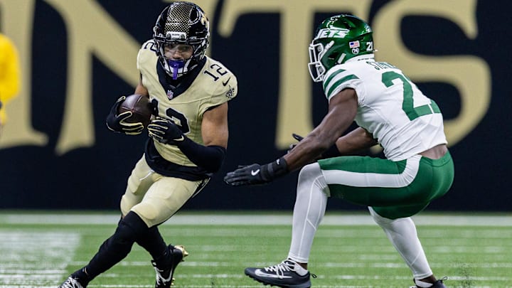 Dec 21, 2025; New Orleans, Louisiana, USA;  New Orleans Saints wide receiver Chris Olave (12) catches a pass and is chased out of bounds bye New York Jets cornerback Brandon Stephens (21) during the first half  at Caesars Superdome. Mandatory Credit: Stephen Lew-Imagn Images