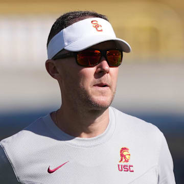 Oct 28, 2023; Berkeley, California, USA; USC Trojans head coach Lincoln Riley (center) walks on the field before the game against the California Golden Bears at California Memorial Stadium. Mandatory Credit: Darren Yamashita-Imagn Images