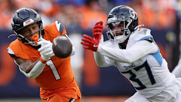 Sep 7, 2025; Denver, Colorado, USA; Tennessee Titans safety Amani Hooker (37) knocks the ball away from Denver Broncos tight end Evan Engram (1) in the first half at Empower Field at Mile High. 