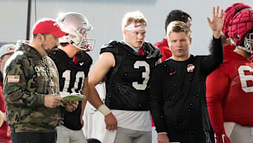 Ohio State Buckeyes quarterbacks Julian Sayin (10) and Lincoln Kienholz (3) talk to head coach Ryan Day