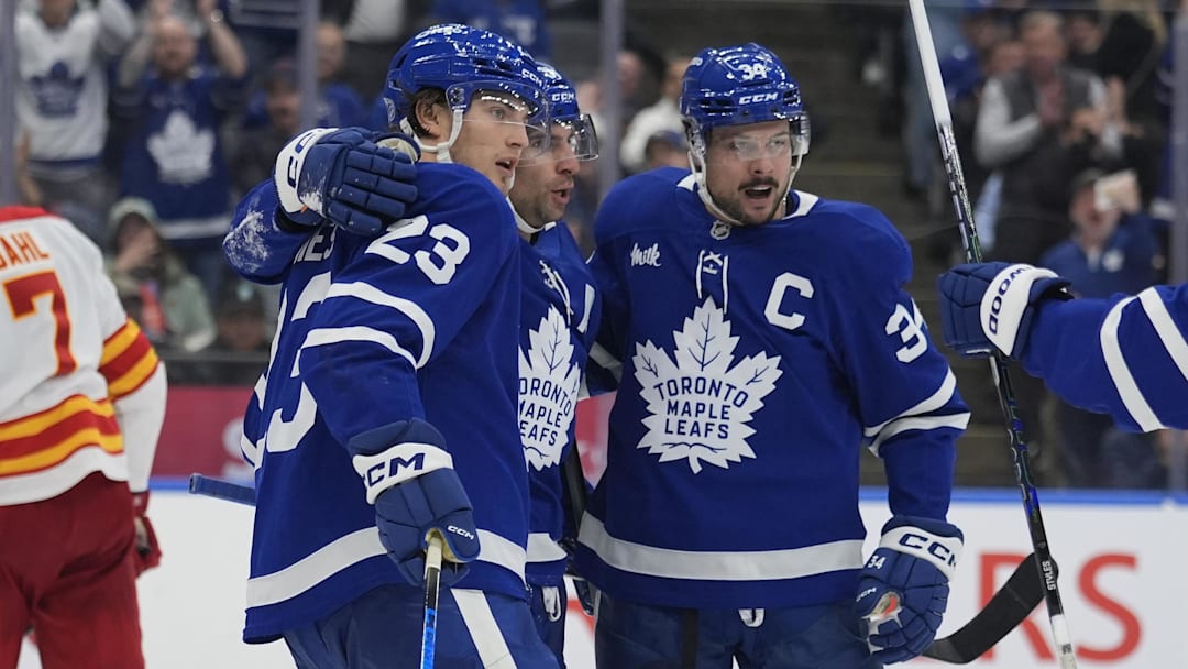 Oct 28, 2025; Toronto, Ontario, CAN; Toronto Maple Leafs forward John Tavares (91) and forward Auston Matthews (34) celebrate a goal by forward Matthew Knies (23) against the Calgary Flames during the third period at Scotiabank Arena. Mandatory Credit: John E. Sokolowski-Imagn Images