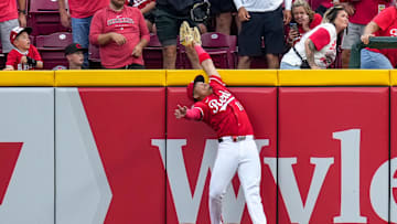 Cincinnati Reds third baseman Noelvi Marte (16) leaps to rob a home run over the wall from Pittsburgh Pirates right fielder Bryan Reynolds (10) in the ninth inning of the MLB National League game between the Cincinnati Reds and the Pittsburgh Pirates at Great American Ball Park in downtown Cincinnati on Thursday, Sept. 25, 2025. The Reds won, 2-1.