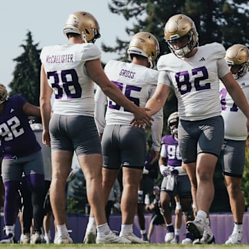 Caleb Johnston (82), shaking hands with punter Jack McCallister, is in the mix to handle the UW long-snapping duties. 