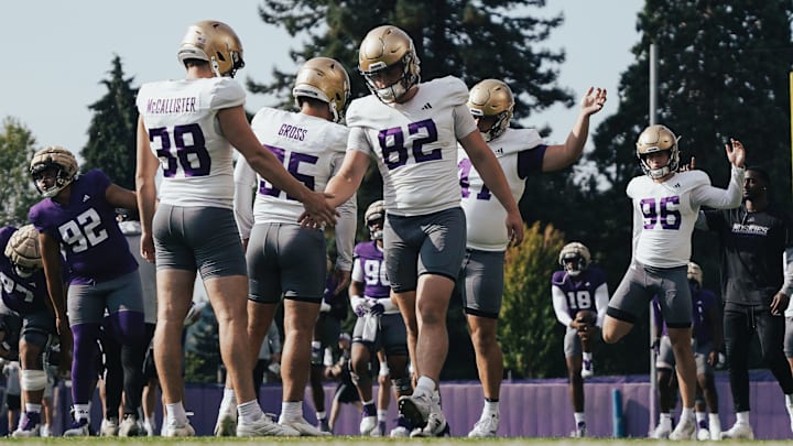 Caleb Johnston (82), shaking hands with punter Jack McCallister, is in the mix to handle the UW long-snapping duties. 