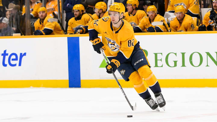 Jan 29, 2025; Nashville, Tennessee, USA;  Nashville Predators center Tommy Novak (82) skates with the puck against the Vancouver Canucks during the second period at Bridgestone Arena. Mandatory Credit: Steve Roberts-Imagn Images