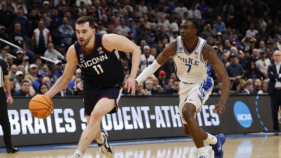 UConn Huskies forward Alex Karaban  dribbles the ball past Duke Blue Devils guard Dame Sarr.