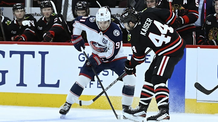 Blue Jackets forward Kent Johnson battles with Blackhawks defenseman Wyatt Kaiser
