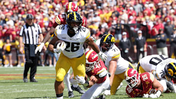 Sep 6, 2025; Ames, Iowa, USA; Iowa Hawkeyes running back Xavier Williams (26) runs with the ball against Iowa State Cyclones linebacker Kooper Ebel (47) during the second quarter at Jack Trice Stadium. Mandatory Credit: Reese Strickland-Imagn Images