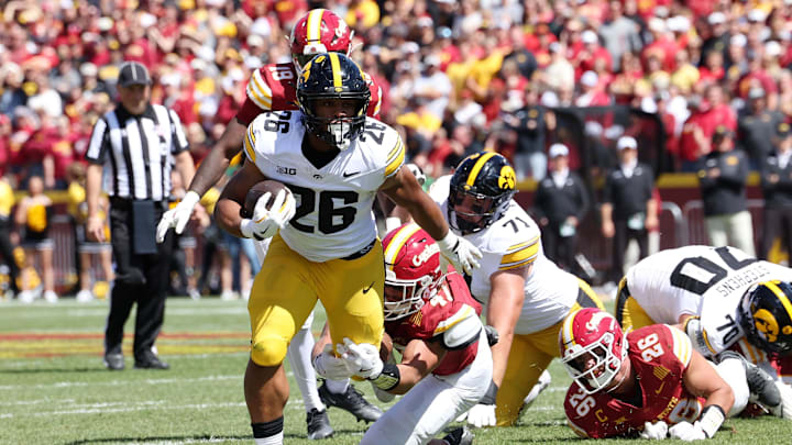 Sep 6, 2025; Ames, Iowa, USA; Iowa Hawkeyes running back Xavier Williams (26) runs with the ball against Iowa State Cyclones linebacker Kooper Ebel (47) during the second quarter at Jack Trice Stadium. Mandatory Credit: Reese Strickland-Imagn Images