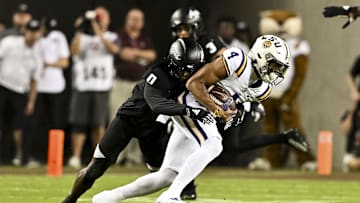 Oct 26, 2024; College Station, Texas, USA; LSU Tigers wide receiver CJ Daniels (4) catches a pass during the first quarter as Texas A&M Aggies linebacker Scooby Williams (0) defends at Kyle Field. Mandatory Credit: Maria Lysaker-Imagn Images. 