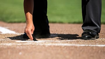 The home plate umpire clears the plate during the championship game of the Big Ten Baseball Tournament between Iowa and Maryland, Sunday, May 28, 2023, at Charles Schwab Field in Omaha, Neb.
