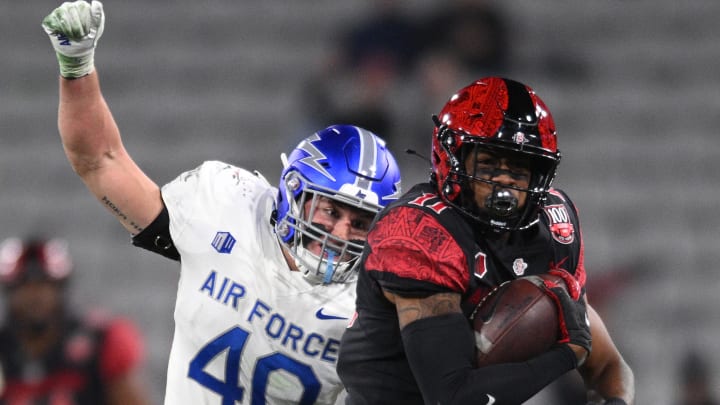 Nov 26, 2022; San Diego, California, USA; San Diego State Aztecs wide receiver Brionne Penny (11) runs with the ball as Air Force Falcons linebacker Alec Mock (40) prepares to punch the ball during the second half at Snapdragon Stadium. Mandatory Credit: Orlando Ramirez-USA TODAY Sports