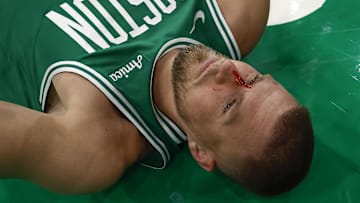 Apr 4, 2025; Boston, Massachusetts, USA; Boston Celtics center Kristaps Porzingis (8) lies on the floor after being cut by an elbow to the nose by Phoenix Suns forward Cody Martin (17) during the second half at TD Garden. Mandatory Credit: Winslow Townson-Imagn Images