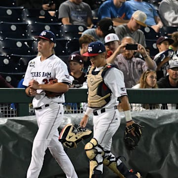 Jun 15, 2024; Omaha, NE, USA;  Texas A&M Aggies starting pitcher Justin Lamkin (33) and catcher Jackson Appel (20) walk to the dugout before the game against the Florida Gators at Charles Schwab Field Omaha. Mandatory Credit: Steven Branscombe-Imagn Images