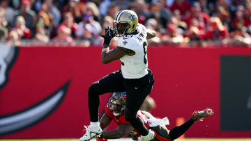 Dec 31, 2023; Tampa, Florida, USA;  New Orleans Saints tight end Juwan Johnson (83) breaks a tackle from Tampa Bay Buccaneers safety Christian Izien (29) in the second quarter at Raymond James Stadium. Mandatory Credit: Nathan Ray Seebeck-USA TODAY Sports