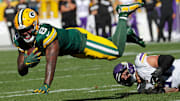 Green Bay Packers running back Josh Jacobs (8) dives for yardage against Minnesota Vikings linebacker Blake Cashman.