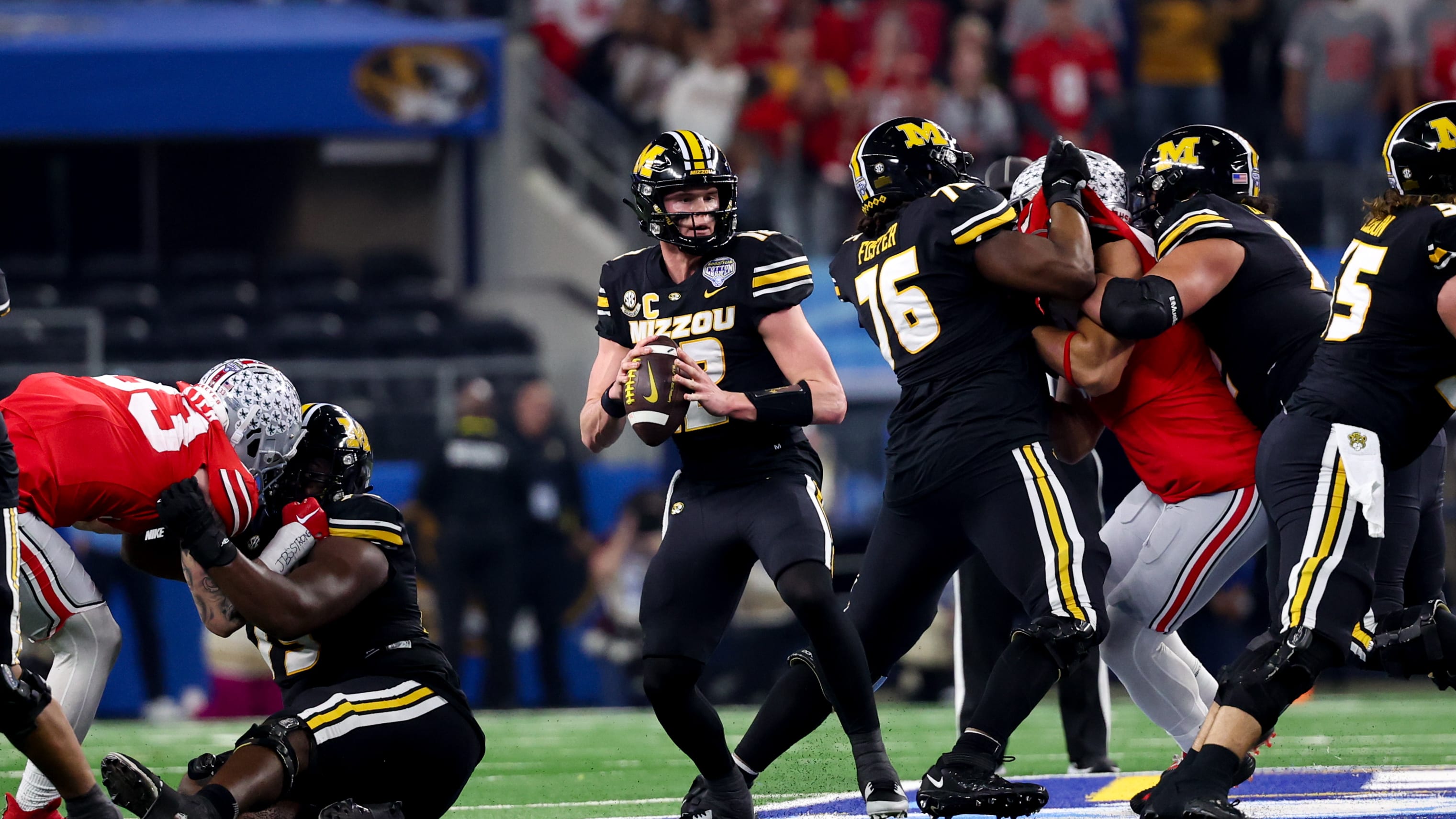Javon Foster, right, protects quarterback Brady Cook, center, on a play during the Cotton Bowl on Dec. 29, 2023.