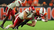 Oct 17, 2025; Miami Gardens, Florida, USA; Miami Hurricanes wide receiver Keelan Marion (0) carries the football against Louisville Cardinals linebacker Kalib Perry (12) during the third quarter at Hard Rock Stadium. Mandatory Credit: Sam Navarro-Imagn Images
