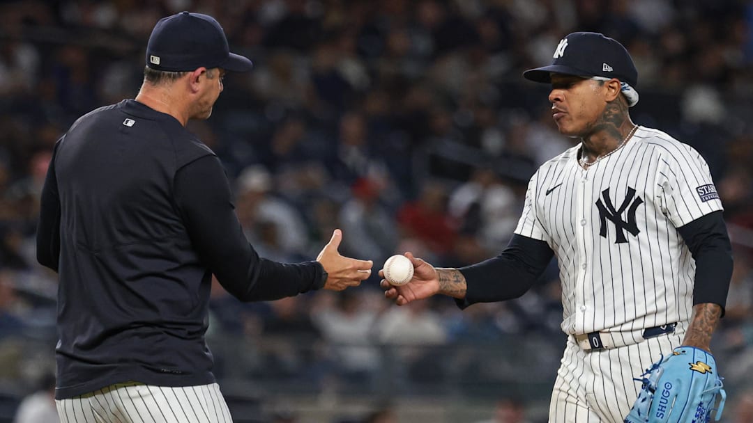 Sep 10, 2024; Bronx, New York, USA; New York Yankees starting pitcher Marcus Stroman (0) hands the ball to manager Aaron Boone (17) after being relieved sixth inning against the Kansas City Royals at Yankee Stadium. Mandatory Credit: Vincent Carchietta-Imagn Images