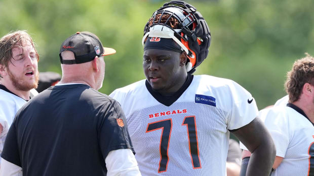 Cincinnati Bengals offensive tackle Amarius Mims (71) talks with offensive line coach Frank Pollack during training camp