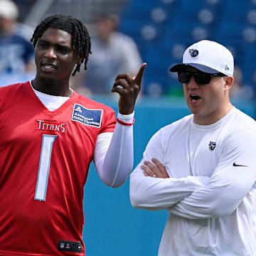 Tennessee Titans quarterback Cam Ward talks with coaches during “Back Together Weekend” training camp practice.