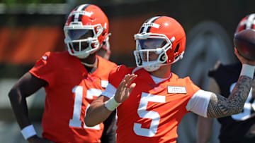 Cleveland Browns quarterback Dillon Gabriel (5) throws as quarterback Shedeur Sanders (12) looks on during NFL rookie minicamp at the Cleveland Browns training facility on Friday, May 9, 2025, in Berea, Ohio.