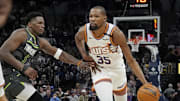 Phoenix Suns forward Kevin Durant dribbles as Minnesota Timberwolves guard Anthony Edwards defends him in an NBA game