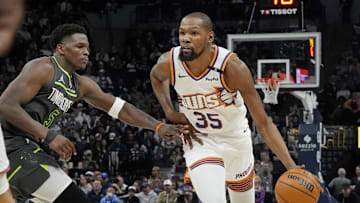 Phoenix Suns forward Kevin Durant dribbles as Minnesota Timberwolves guard Anthony Edwards defends him in an NBA game