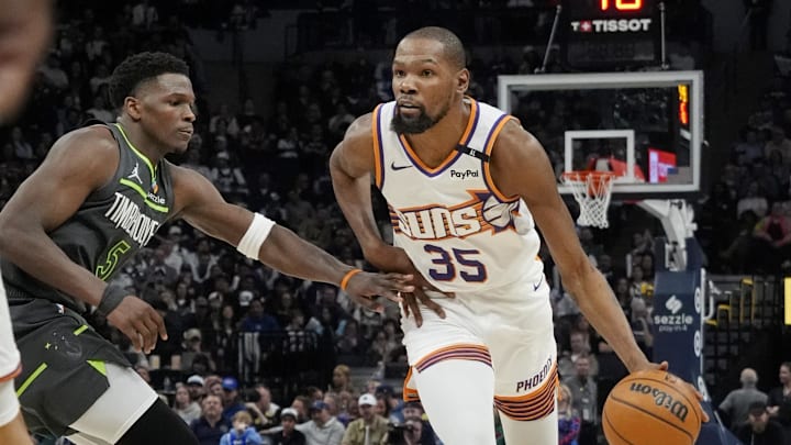 Phoenix Suns forward Kevin Durant dribbles as Minnesota Timberwolves guard Anthony Edwards defends him in an NBA game