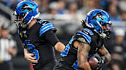 Detroit Lions quarterback Jared Goff (16) hands the ball to running back Jahmyr Gibbs (26).