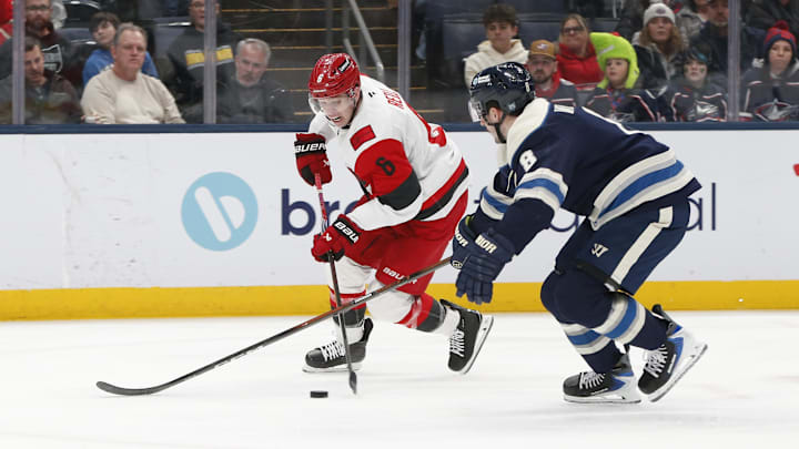 Mar 17, 2026; Columbus, Ohio, USA; Carolina Hurricanes defenseman Mike Reilly (6) carries the puck as Columbus Blue Jackets defenseman Zach Werenski (8) defends during the third period at Nationwide Arena. Mandatory Credit: Russell LaBounty-Imagn Images