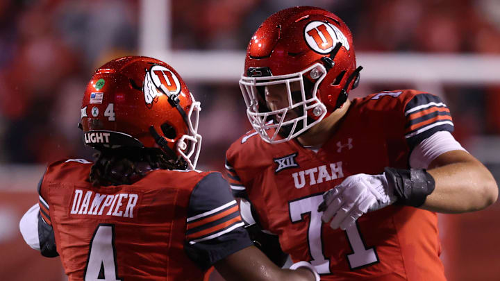 Oct 11, 2025; Salt Lake City, Utah, USA; Utah Utes quarterback Devon Dampier (4) celebrates scoring a touchdown against the Arizona State Sun Devils with Utah Utes offensive lineman Caleb Lomu (71) during the second quarter at Rice-Eccles Stadium. Mandatory Credit: Rob Gray-Imagn Images