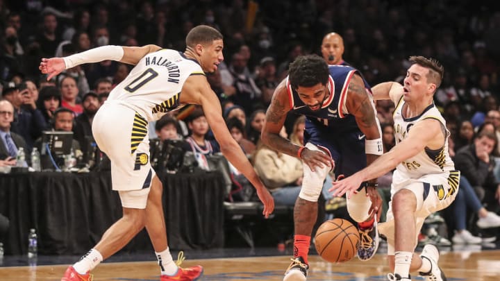 Apr 10, 2022; Brooklyn, New York, USA;  Brooklyn Nets guard Kyrie Irving (11) is double teamed by Indiana Pacers guards Tyrese Haliburton (0) and T.J. McConnell (9) in the third quarter at Barclays Center. Mandatory Credit: Wendell Cruz-USA TODAY Sports