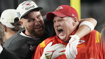 Kansas City Chiefs head coach Andy Reid celebrates on the podium with tight end Travis Kelce (87) after defeating the Philadelphia Eagles in Super Bowl LVII.