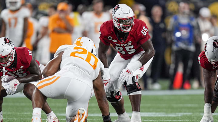 Sep 7, 2024; Charlotte, North Carolina, USA; North Carolina State Wolfpack offensive tackle Jacarrius Peak (65) lines up against Tennessee Volunteers defensive lineman Bryson Eason (20) during the first quarter at the Dukes Mayo Classic at Bank of America Stadium. Mandatory Credit: Jim Dedmon-Imagn Images