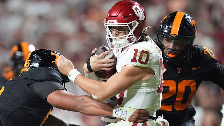 Oklahoma quarterback John Mateer is tackled by Tennessee defenders.