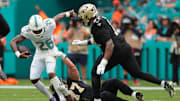 Miami Dolphins cornerback Rasul Douglas (26) carries the ball after making an interception as New Orleans Saints offensive tackle Dillon Radunz (77) attempts to make the tackle during the first half at Hard Rock Stadium.